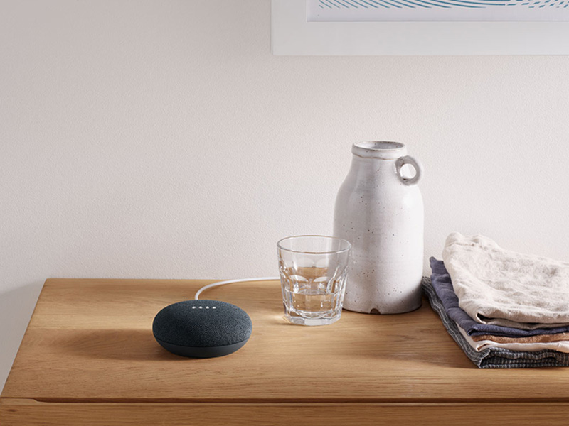 Google Nest Mini verbonden met kabel op houten bureau