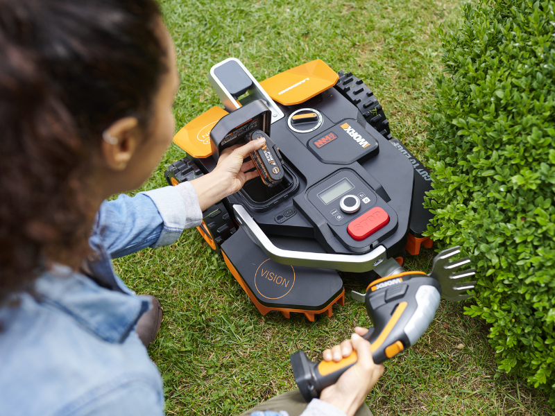 Vrouw voert onderhoud van Worx Landroid Vision uit in tuin